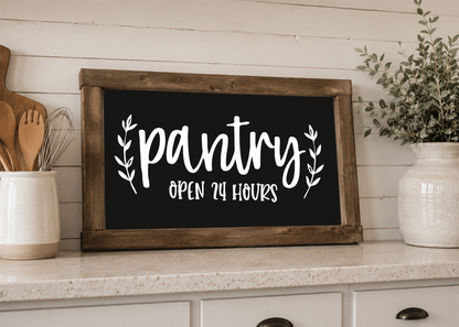Wooden sign with 'pantry open 24 hours' text on a kitchen counter.