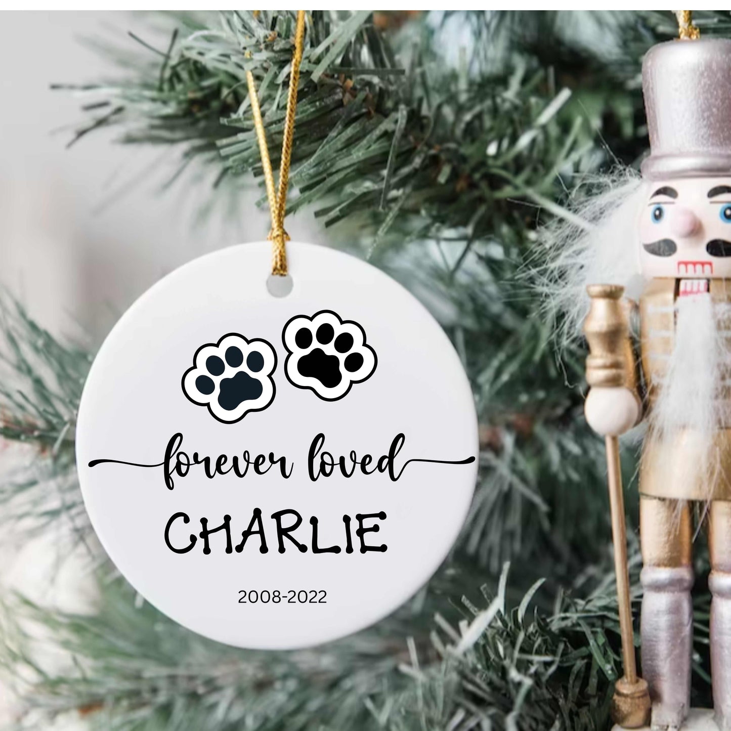 Personalized ceramic dog or cat Christmas ornament with paw prints and name "Charlie" memorial keepsake hanging on tree