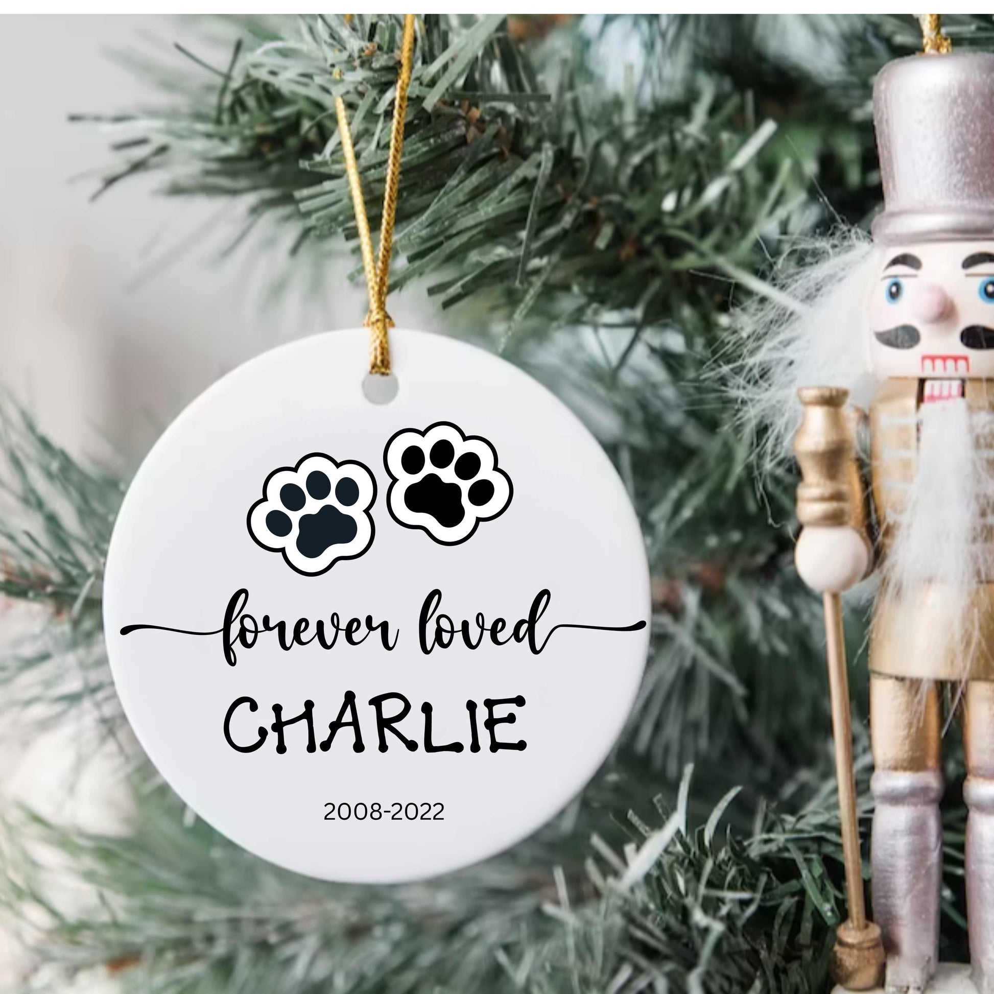 Personalized ceramic dog or cat Christmas ornament with paw prints and name "Charlie" memorial keepsake hanging on tree