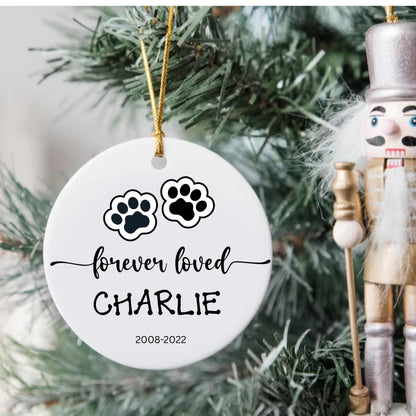 Personalized ceramic dog or cat Christmas ornament with paw prints and name "Charlie" memorial keepsake hanging on tree
