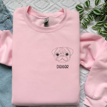 Pink classic crewneck sweater with custom embroidered pug face and the name Dexter in block font.