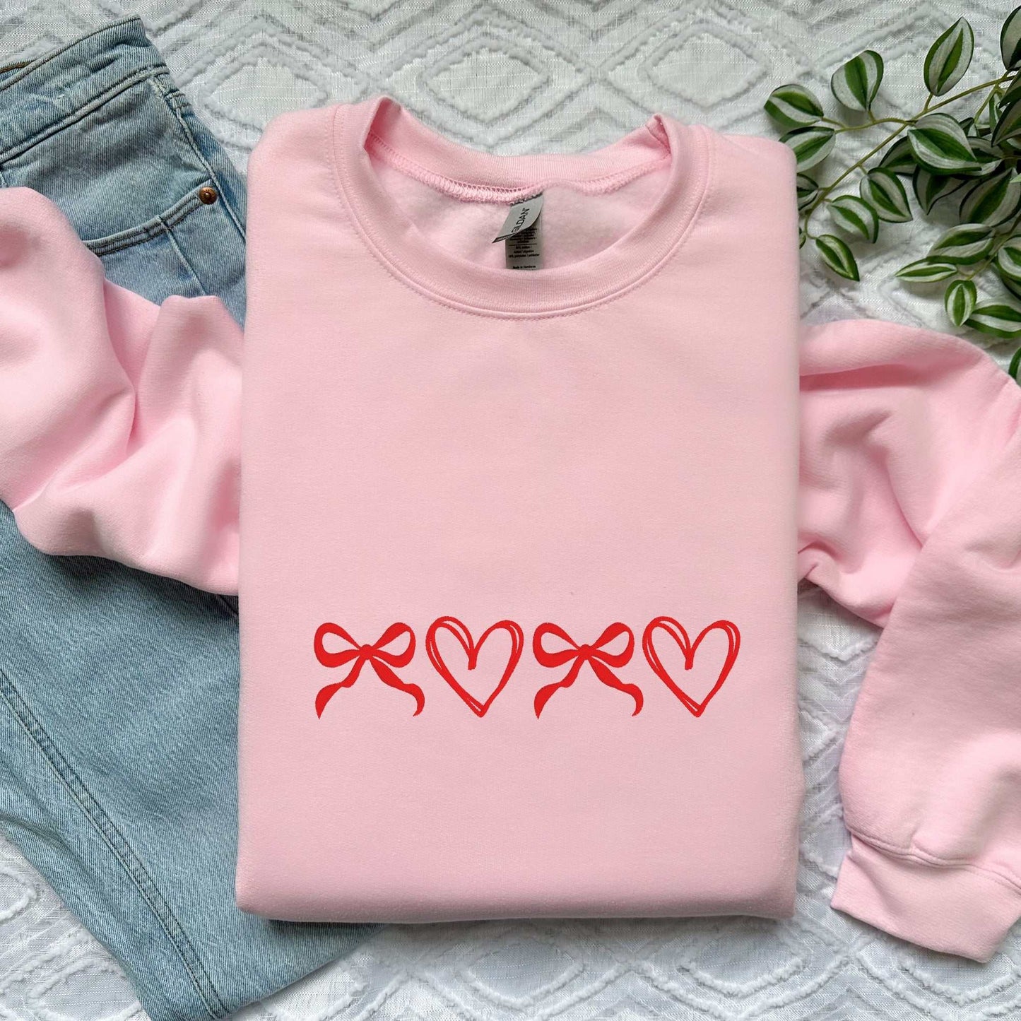 Custom embroidered pink sweatshirt with red bows and hearts design, perfect for gifting.