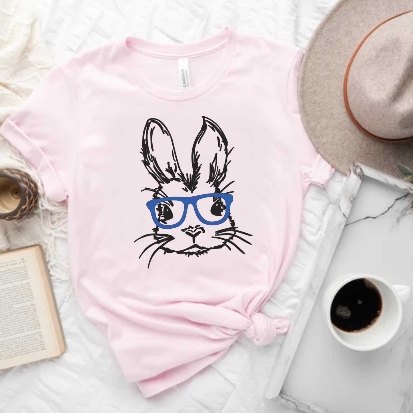 Unisex Easter bunny with glasses graphic tee in pastel pink, perfect for spring celebrations.