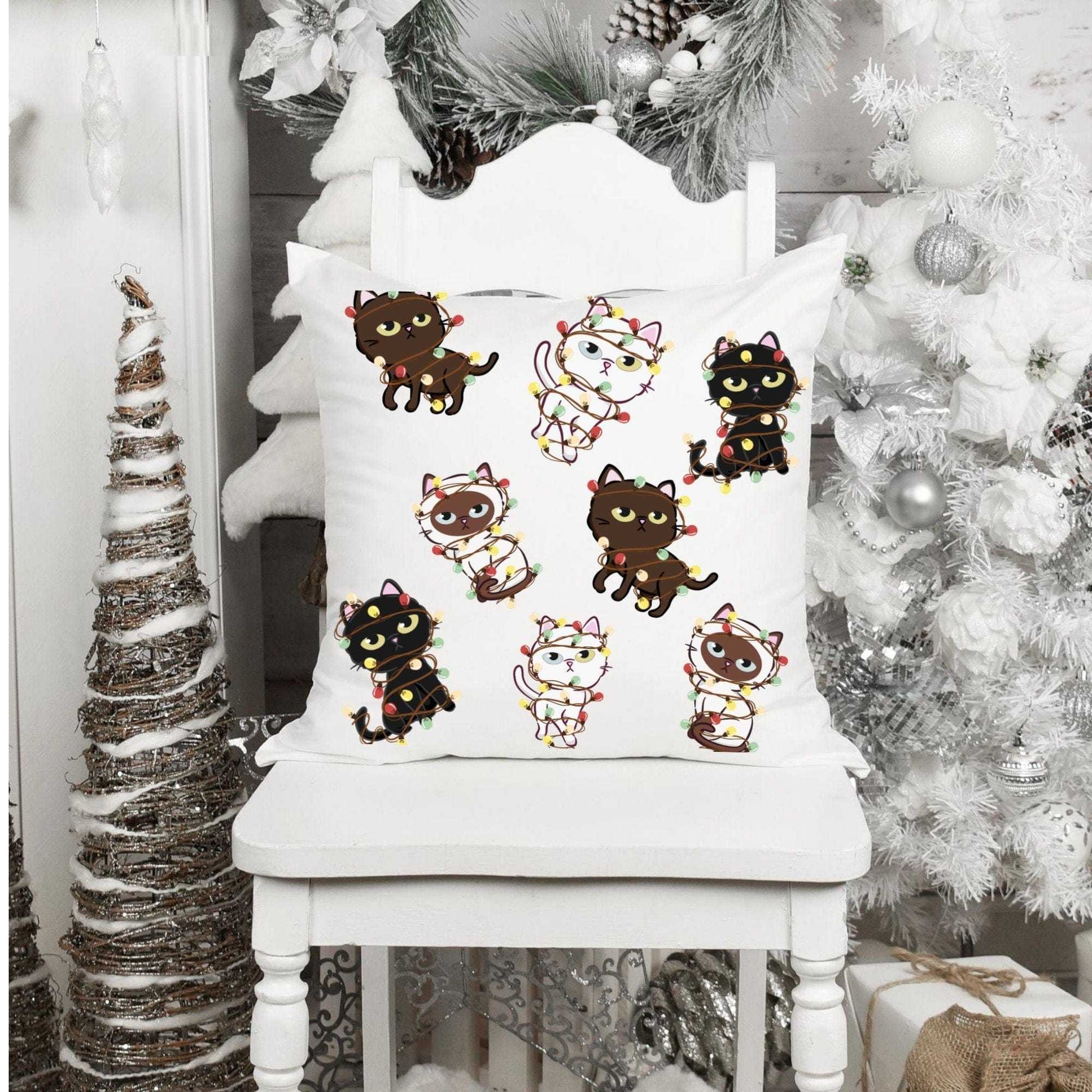 Festive Christmas cat pillow case with cute kittens in lights on a white chair.