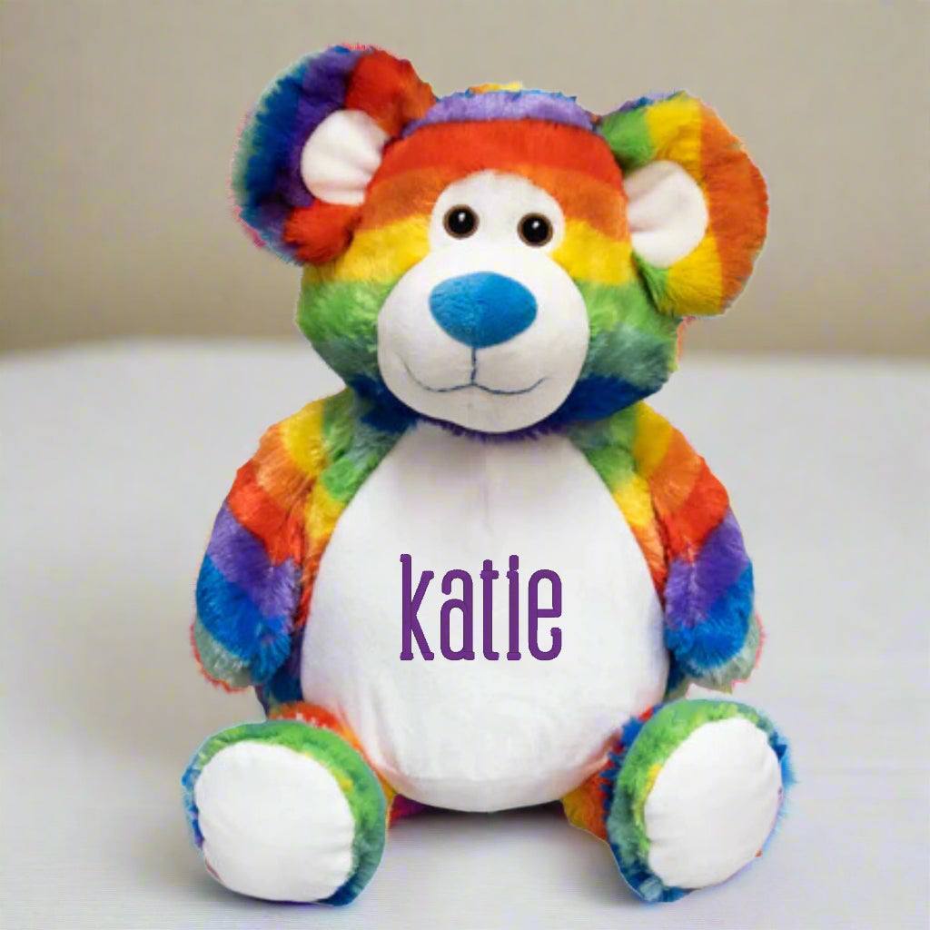 Personalized rainbow teddy bear baby gift with embroidered name.