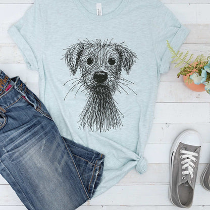 Light blue women's casual t-shirt with black scribble sketch dog graphic, paired with blue jeans and gray sneakers.