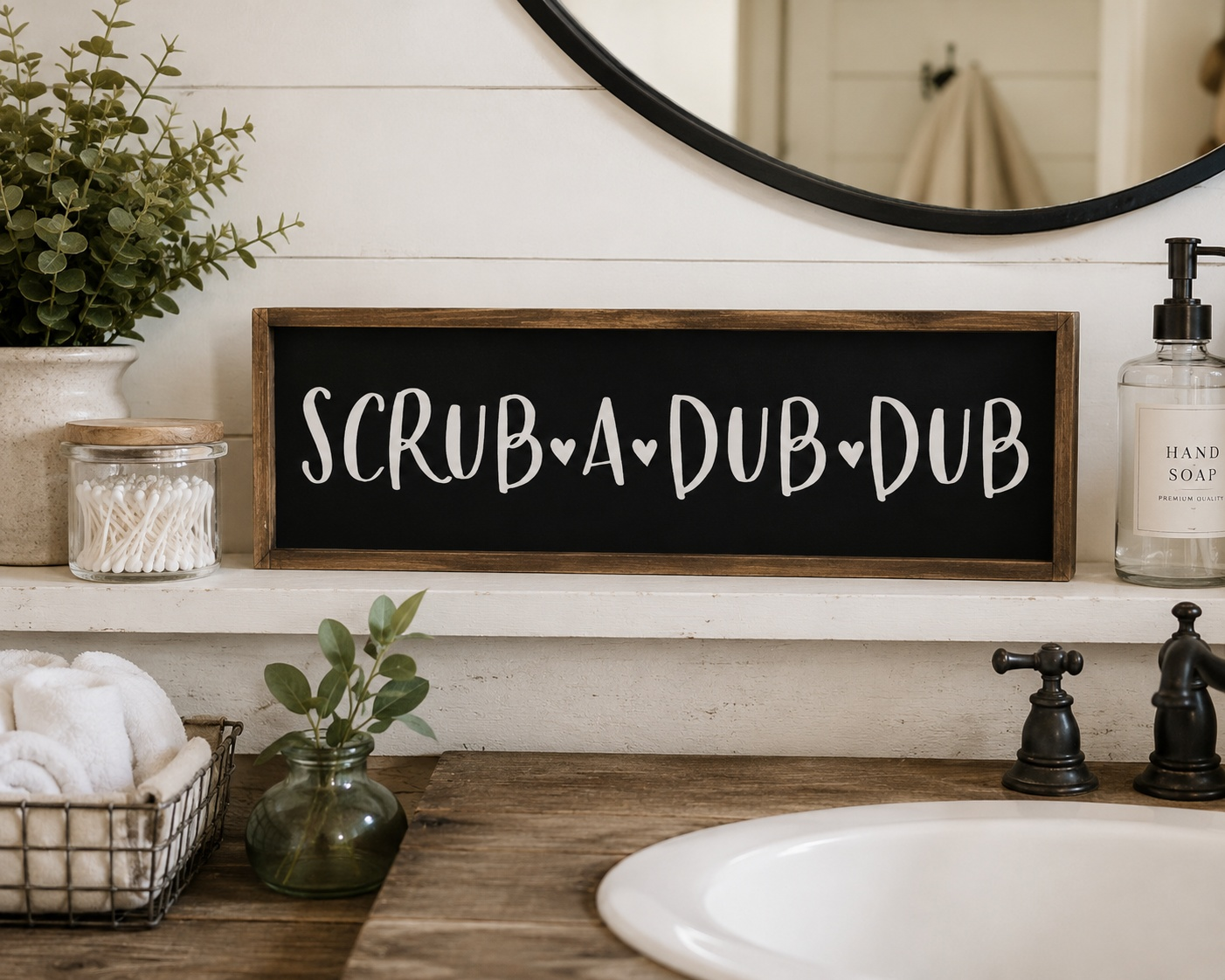 Bathroom vanity with 'Scrub A Dub Dub' sign, plants, and soap dispenser.
