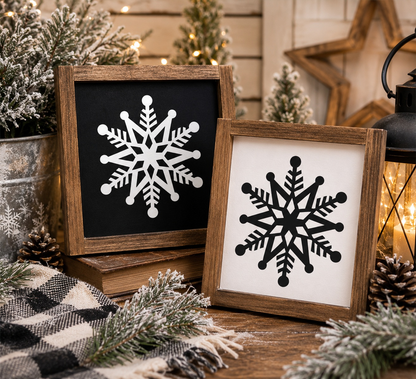 Two wooden-framed snowflake art pieces on a festive background with Christmas decorations.