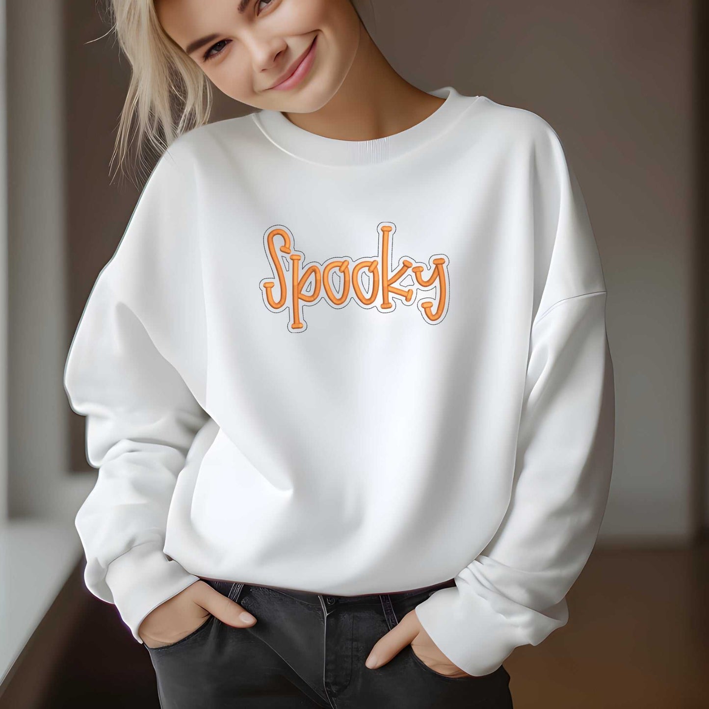 woman wearing cozy white crewneck sweater with orange "Spooky" embroidery for fall Halloween