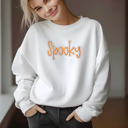 woman wearing cozy white crewneck sweater with orange "Spooky" embroidery for fall Halloween