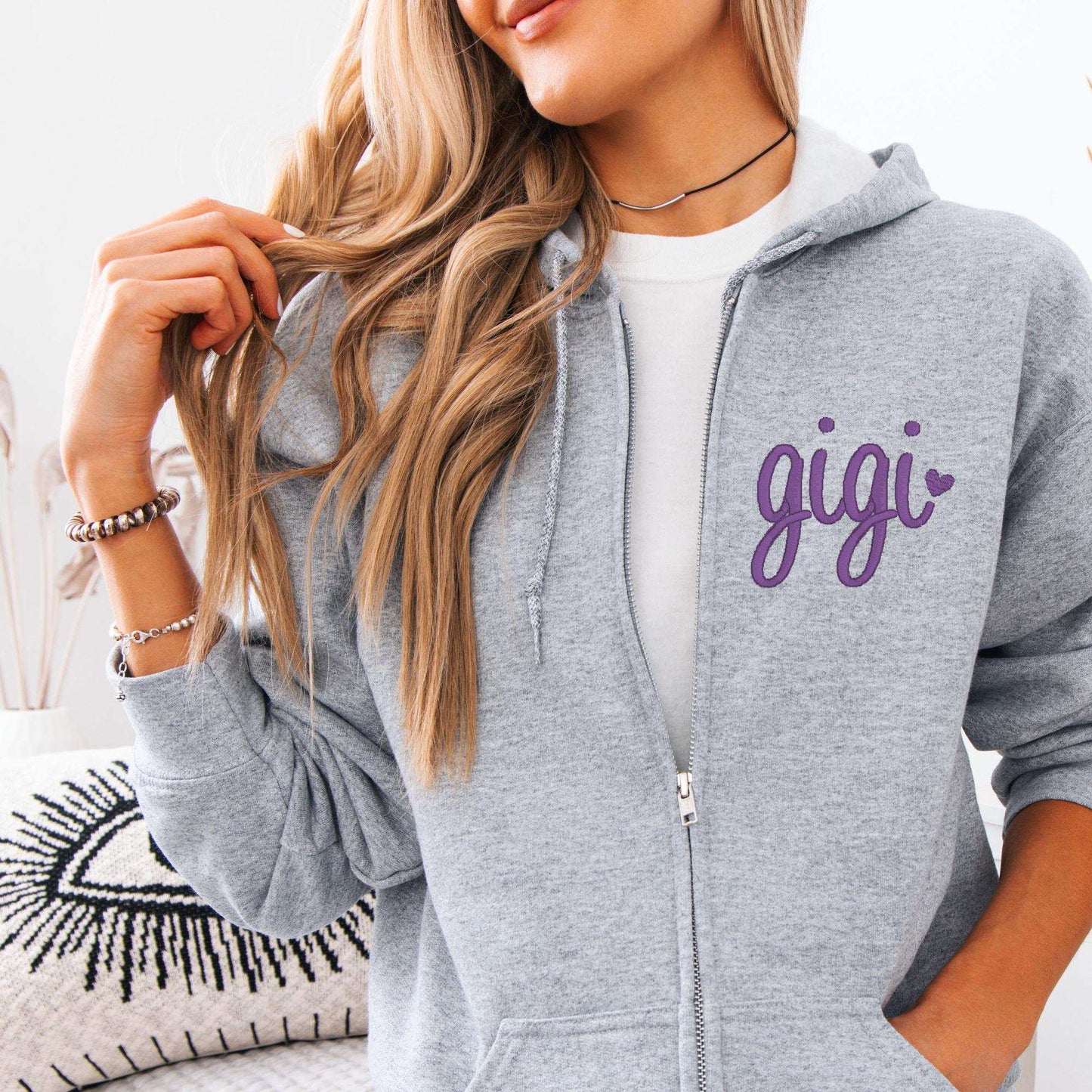 Custom embroidered zip-up hoodie with personalized name on sleeve in multiple colors and sizes.