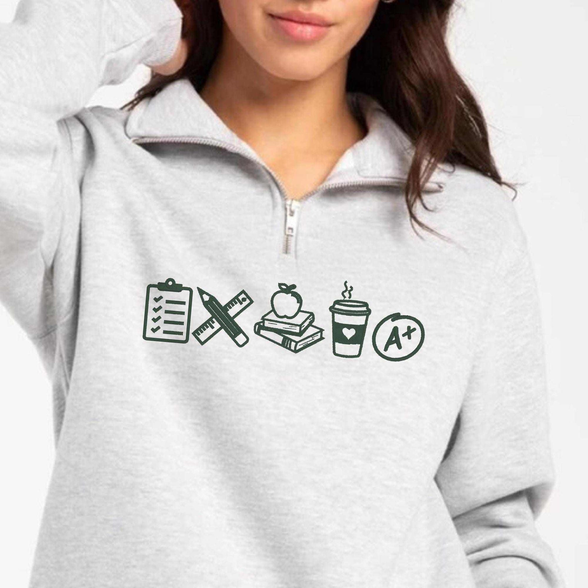 Cozy teacher icon embroidered sweater with school-themed icons and quarter zip design