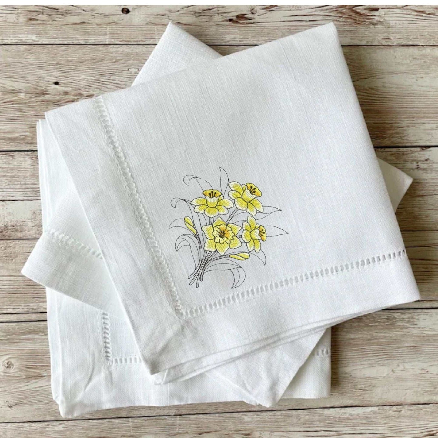 Reusable botanical-themed cloth napkin with floral design and hemstitch detailing.