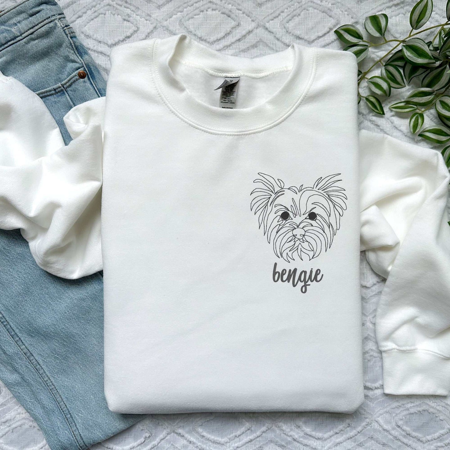 White classic crewneck sweater with embroidered Yorkshire Terrier face and custom name "bengie" in cursive font.