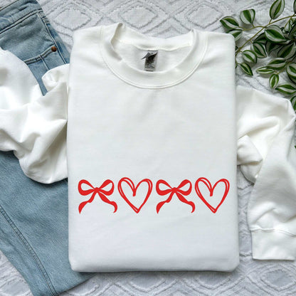 Custom coquette sweatshirt with red bow and heart embroidery on white fabric, perfect Valentine’s or Mother’s Day gift.
