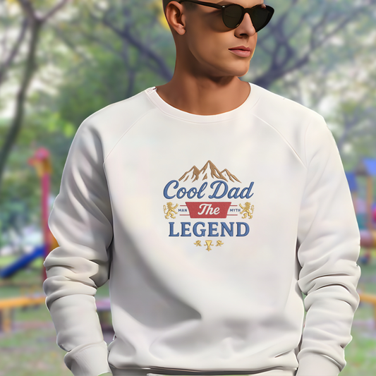 Person wearing a white sweatshirt with 'Cool Dad The Legend' text in an outdoor setting