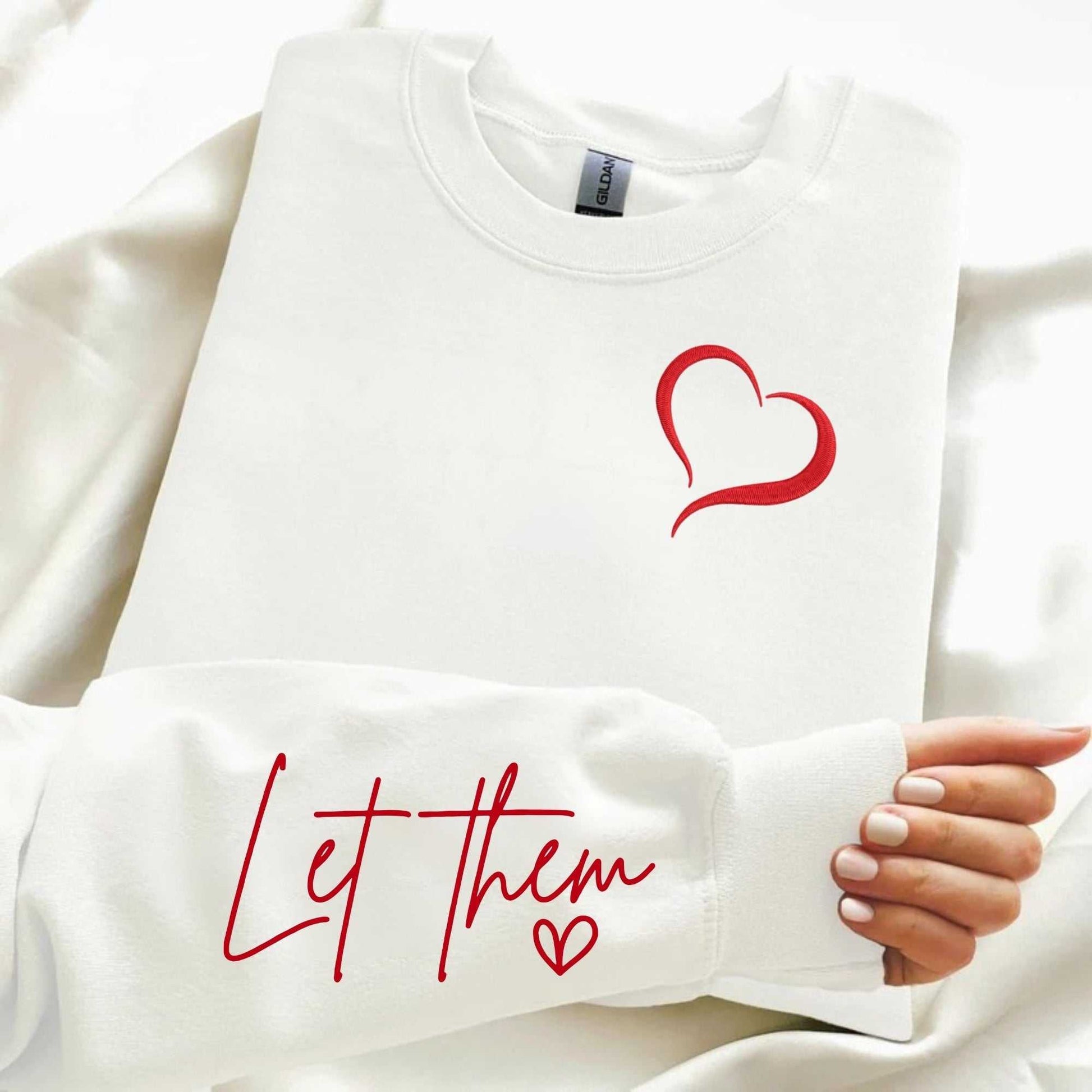 Let Them embroidered cozy sweatshirt with heart design on chest and affirmation on sleeve.