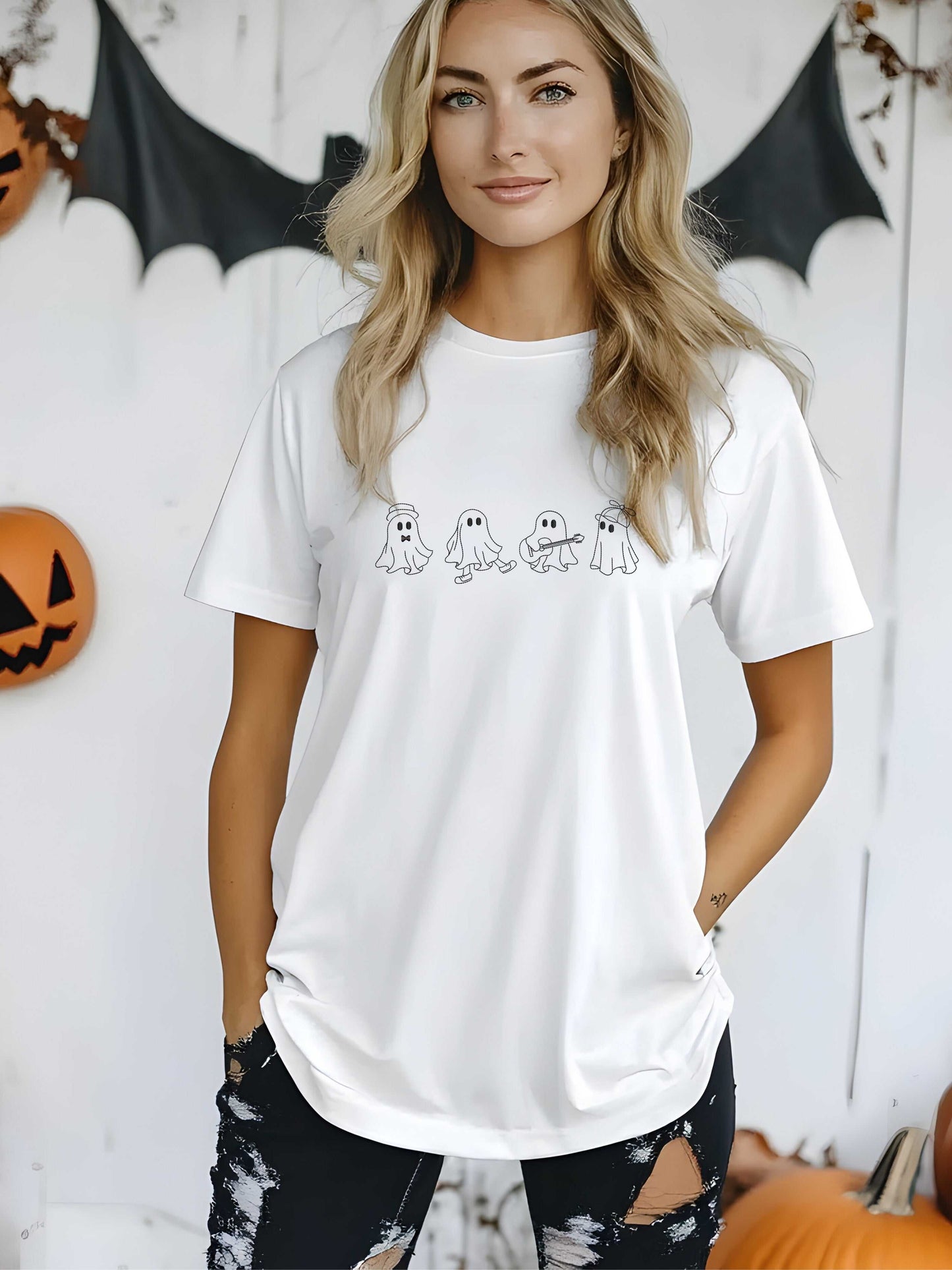 woman wearing white embroidered ghost crew Halloween t-shirt with black distressed pants in fall decor setting