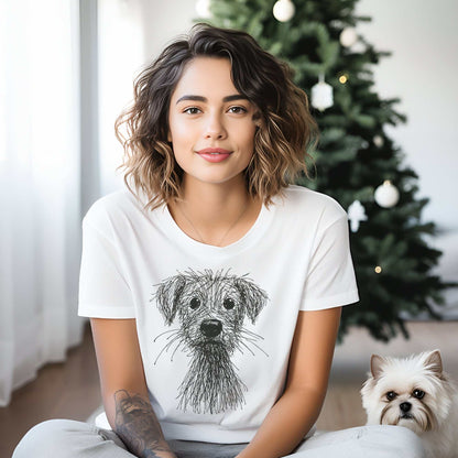 Woman wearing a white t-shirt with a dog illustration, sitting next to a small white dog in a room with a Christmas tree.