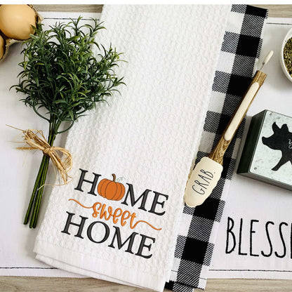 Thanksgiving-themed embroidered tea towel with "Home Sweet Home" text and pumpkin design, 100% cotton kitchen decor, 19x28 inches, ultra absorbent and machine washable.