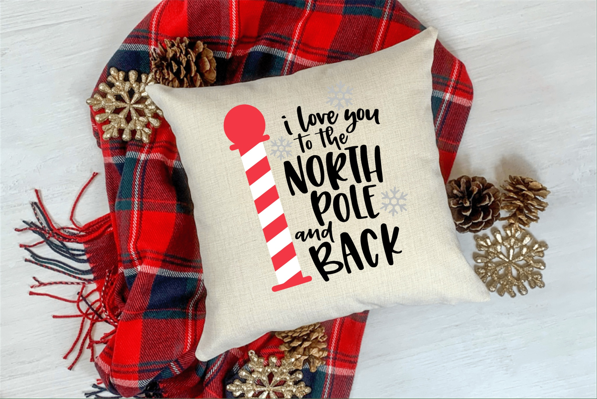 Natural cotton pillow cover with "I Love You to the North Pole and Back" design, red and black plaid background, festive pinecones and snowflakes.