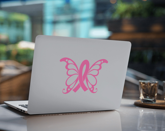 Pink butterfly cancer awareness car sticker on a laptop in a cafe setting.