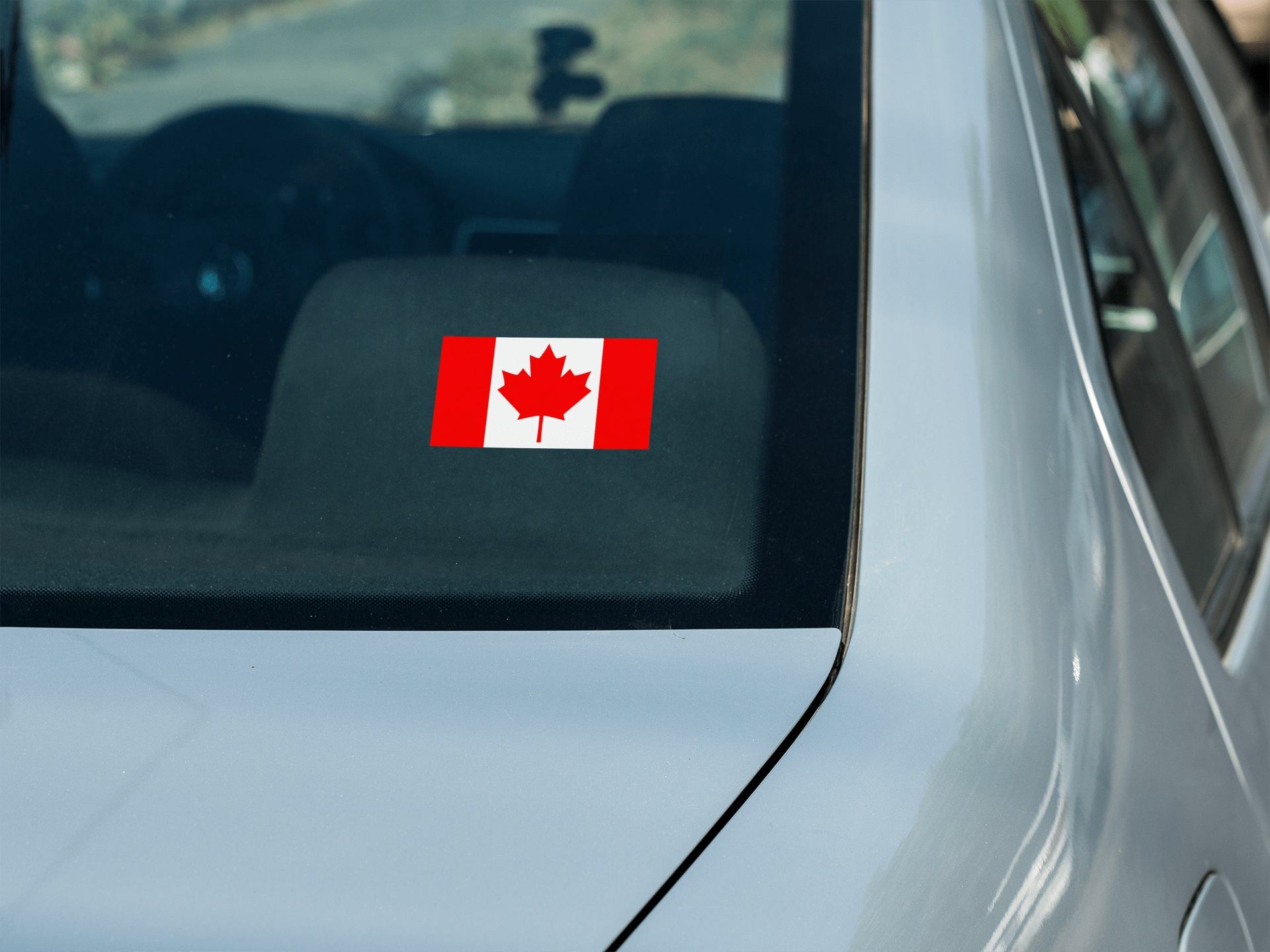 Canadian flag decal sticker on car window.