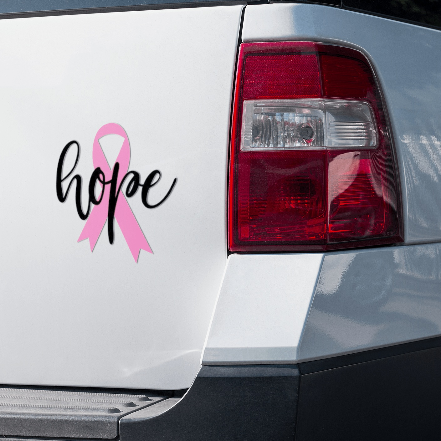 Pink ribbon "Hope" vinyl sticker on car back, symbol of support and resilience.