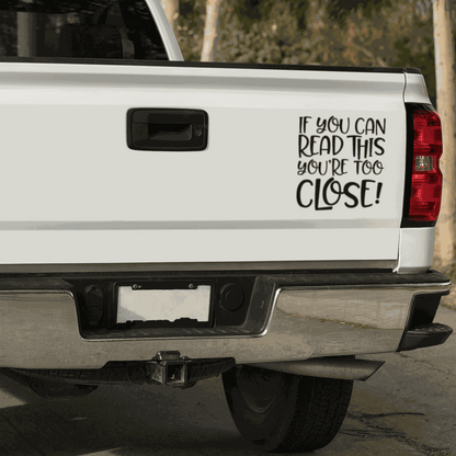 Car decal with quote "If you can Read This You are too Close!" on a white truck tailgate.