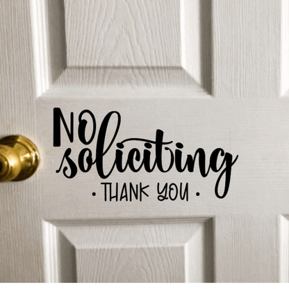 No Soliciting vinyl door decal on white door.