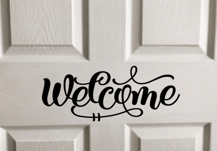 Welcome vinyl door decal on white wood panel door.