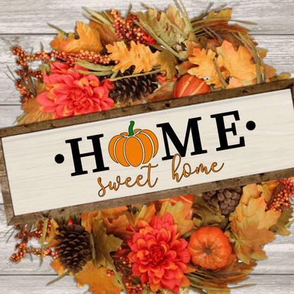 Home Sweet Home wood sign with pumpkin illustration, surrounded by autumn leaves and flowers.