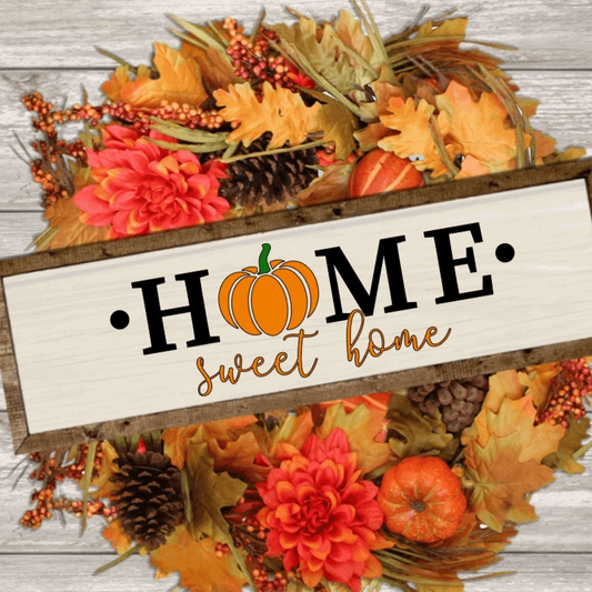 Home Sweet Home wood sign with pumpkin illustration, surrounded by autumn leaves and flowers.