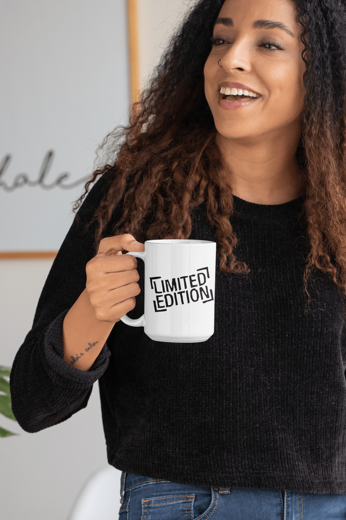 Limited edition ceramic mug with inspiring design held by a smiling woman.