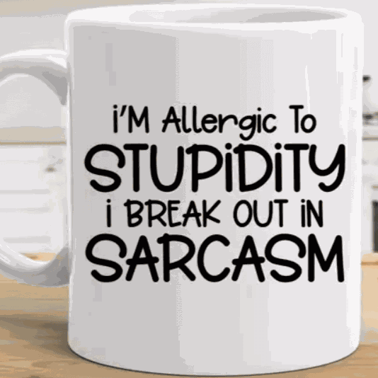 Ceramic coffee mug with "I'm Allergic to Stupidity I Break Out in Sarcasm" design.
