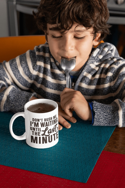 Ceramic coffee mug with "Don't Rush Me" text displayed on table with a child eating nearby.