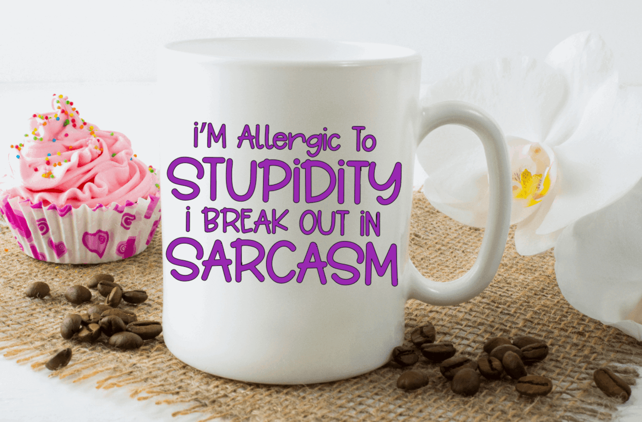 Ceramic coffee mug with "I'm Allergic to Stupidity, I Break Out in Sarcasm" text in purple.