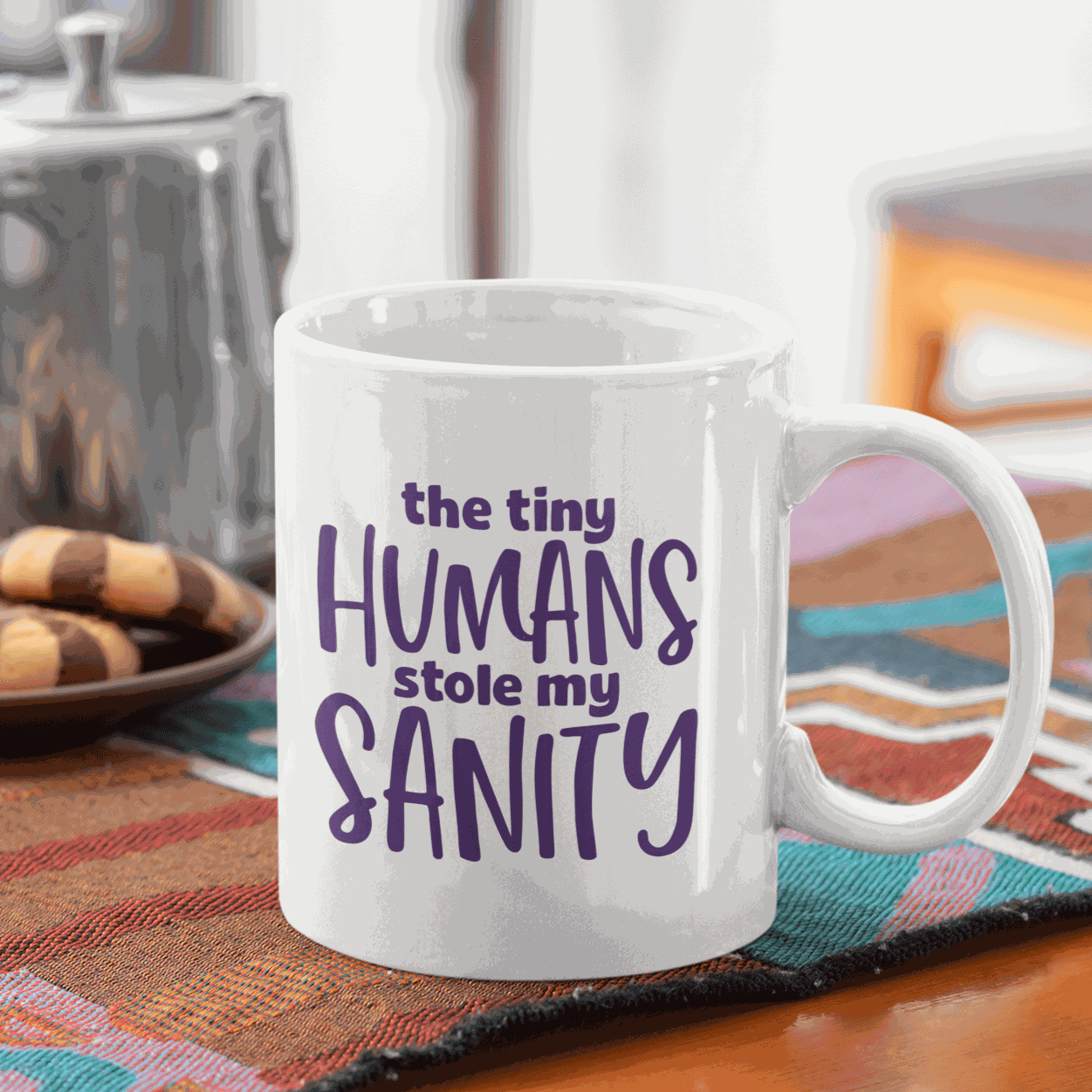 Ceramic mug with the quote "The Tiny Humans Stole my Sanity" in purple lettering, ideal for new parents.
