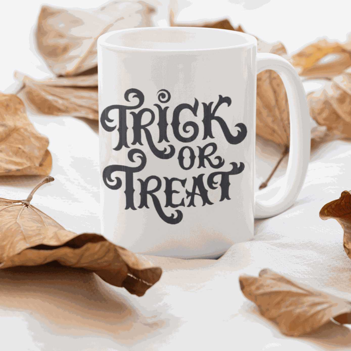Halloween ceramic mug with "Trick or Treat" design on one side, surrounded by autumn leaves.