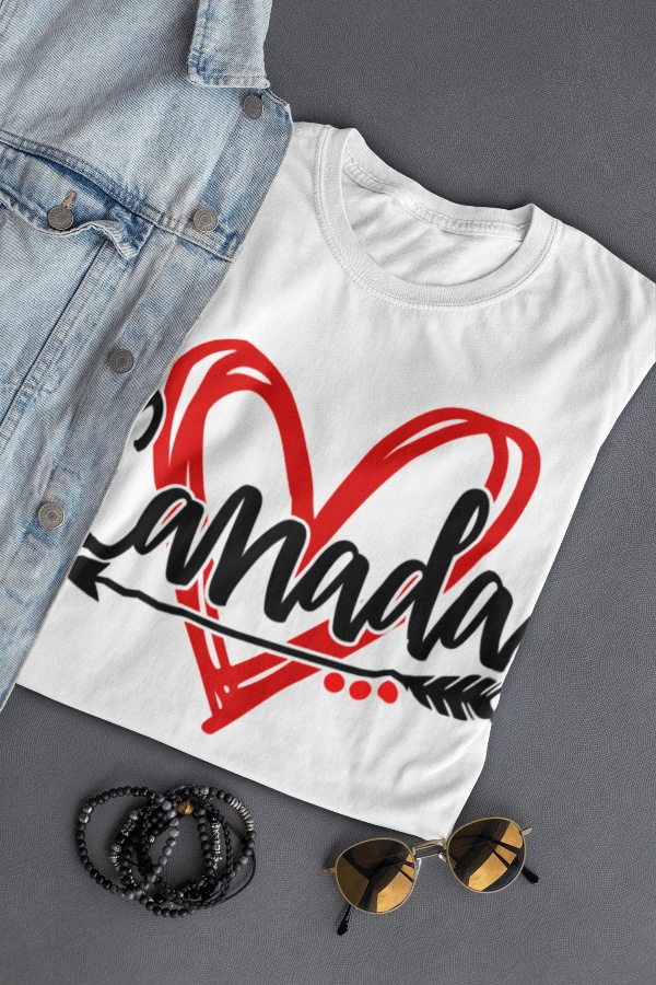 Canadian T-shirt with red heart and black arrow design, laid next to