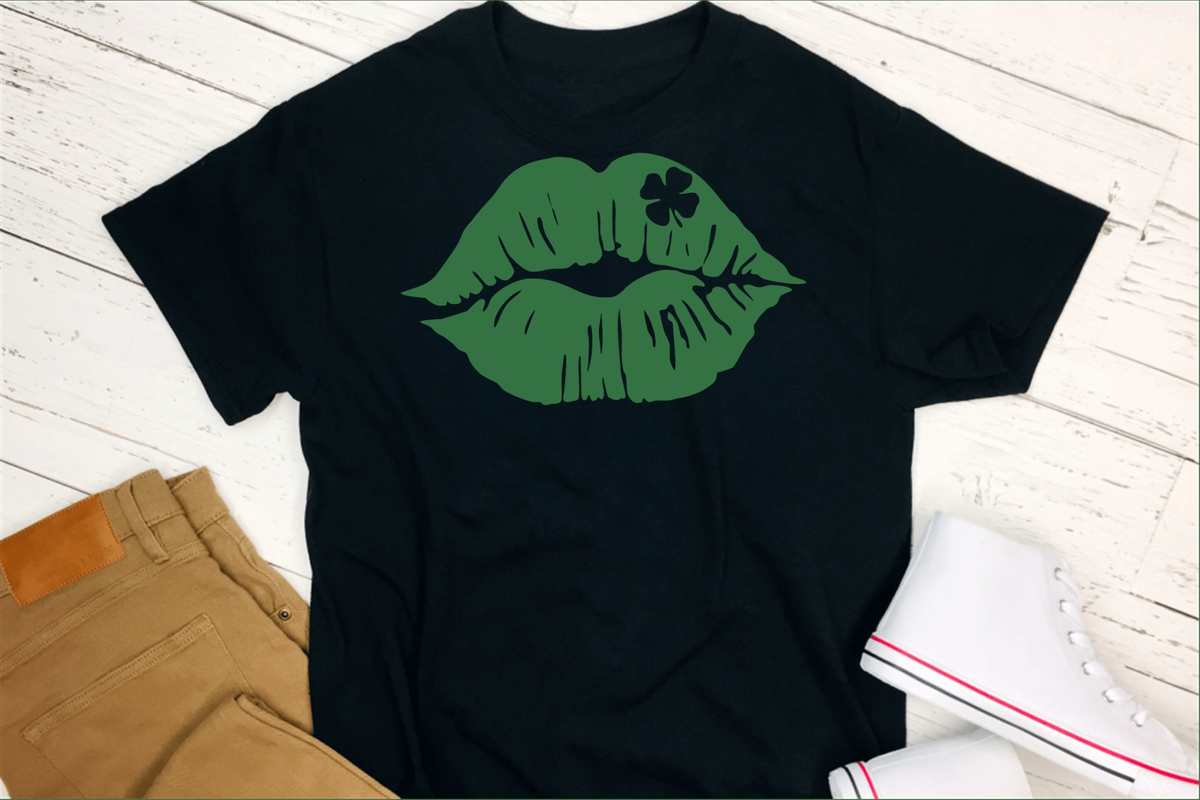 St. Patrick's Day T-shirt in black cotton, featuring bold green lips with a small shamrock printed on the upper lip.