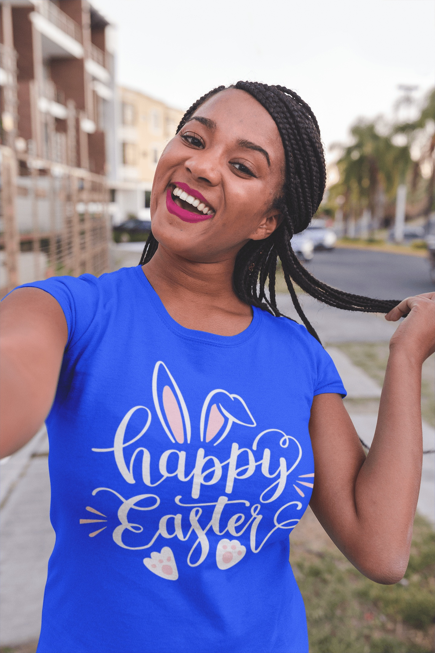 Woman wearing blue Happy Easter shirt with bunny graphic outdoors smiling