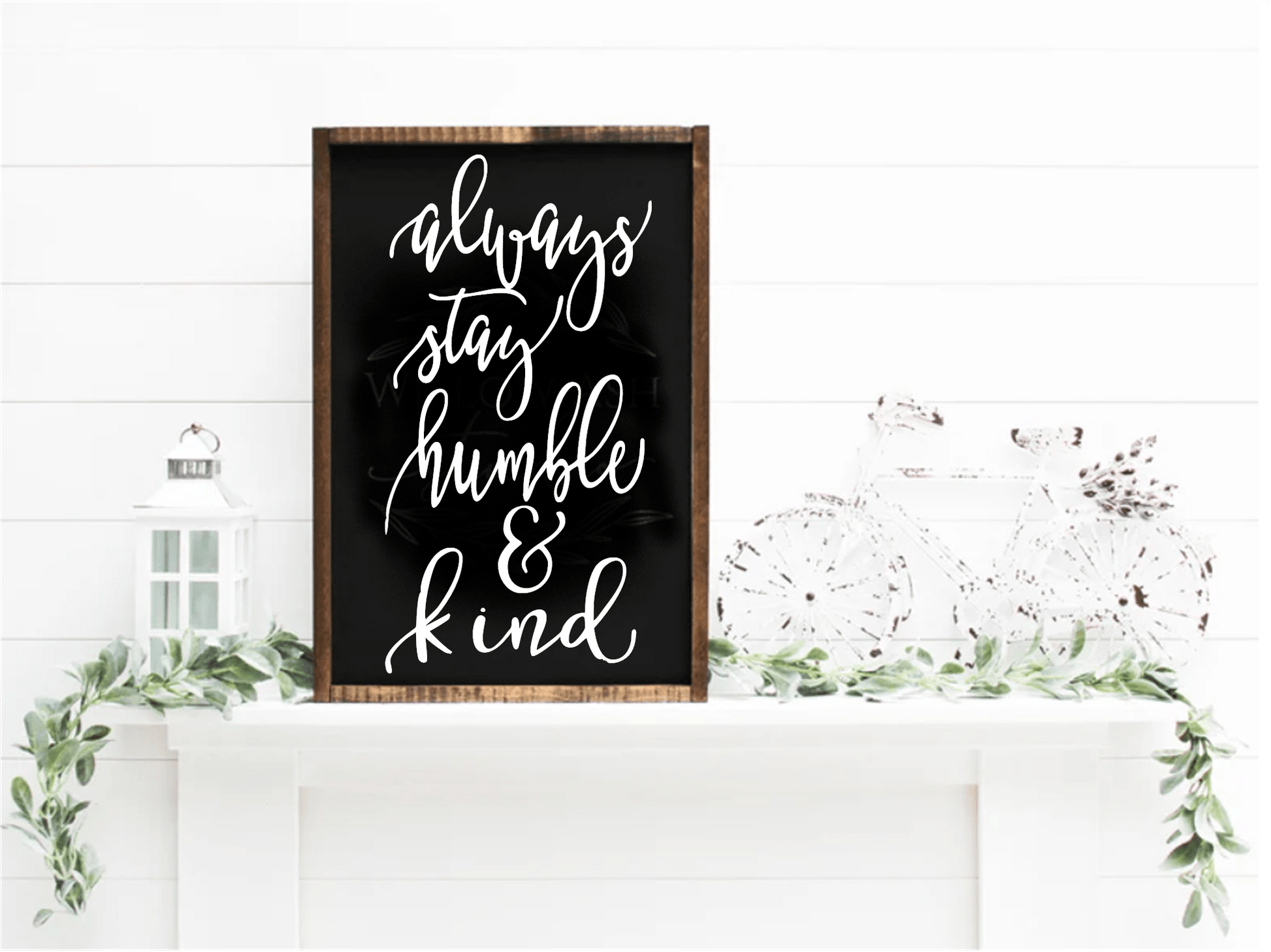 Always Stay Humble & Kind wood sign, handcrafted with black background and white lettering, displayed on a mantel with greenery.