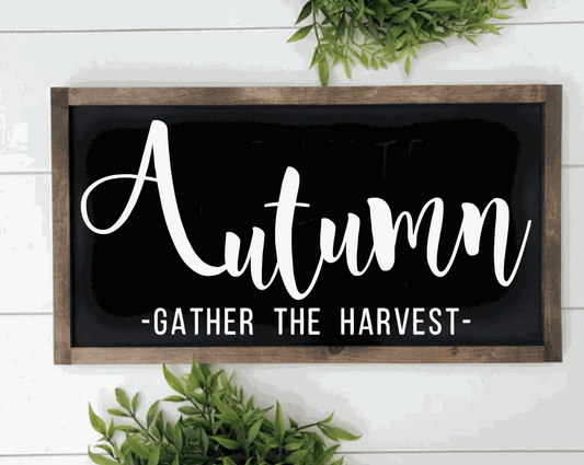 Handcrafted autumn wood sign with "Gather the Harvest" text in white on black background, framed in rustic pine wood.