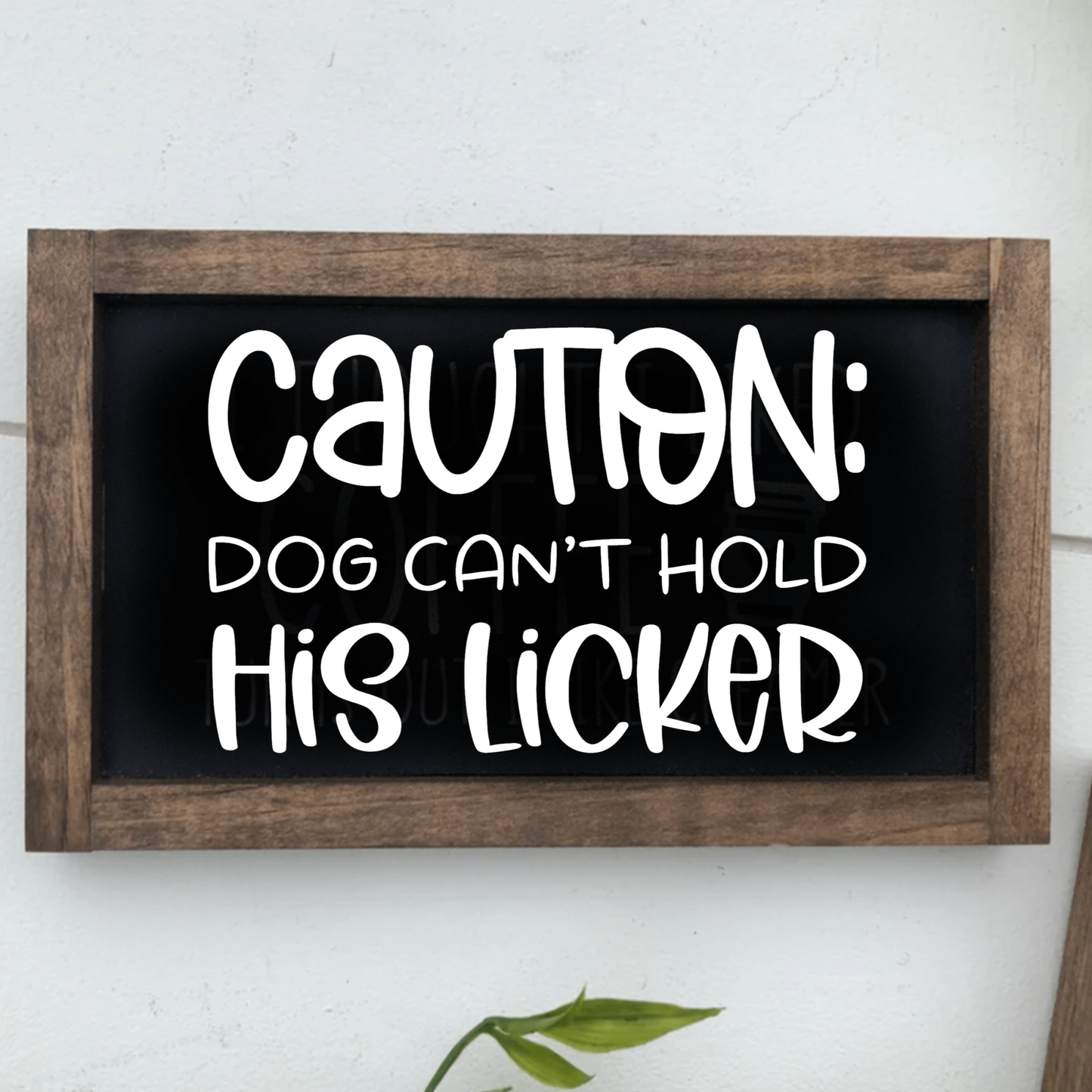 Caution Dog Can't Hold His Licker Framed Sign with rustic finish and white lettering on black background.