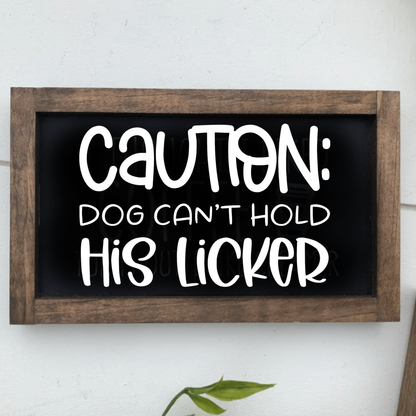 Caution Dog Can't Hold His Licker Framed Sign with rustic finish and white lettering on black background.