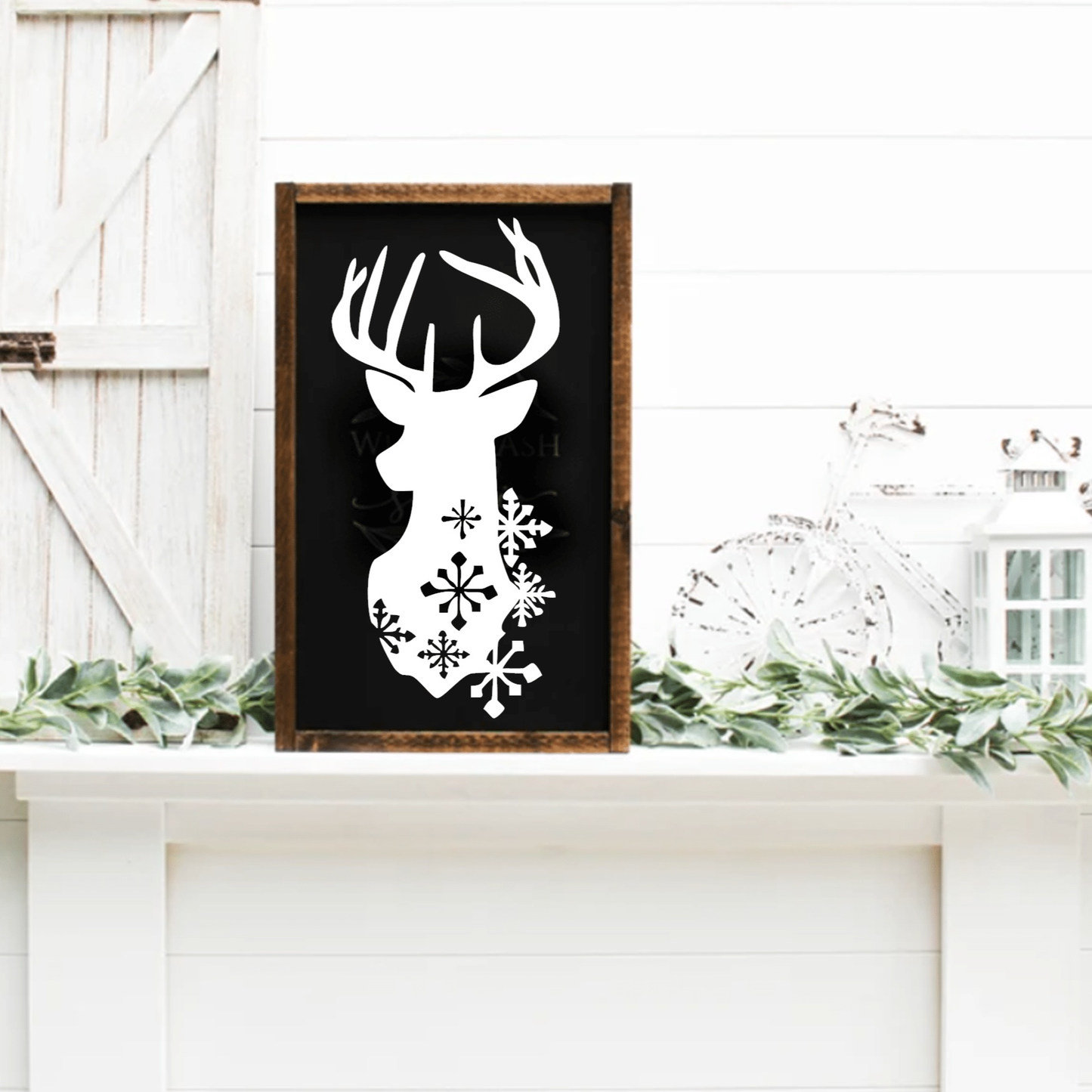 Framed Christmas deer head sign with snowflakes on black background.