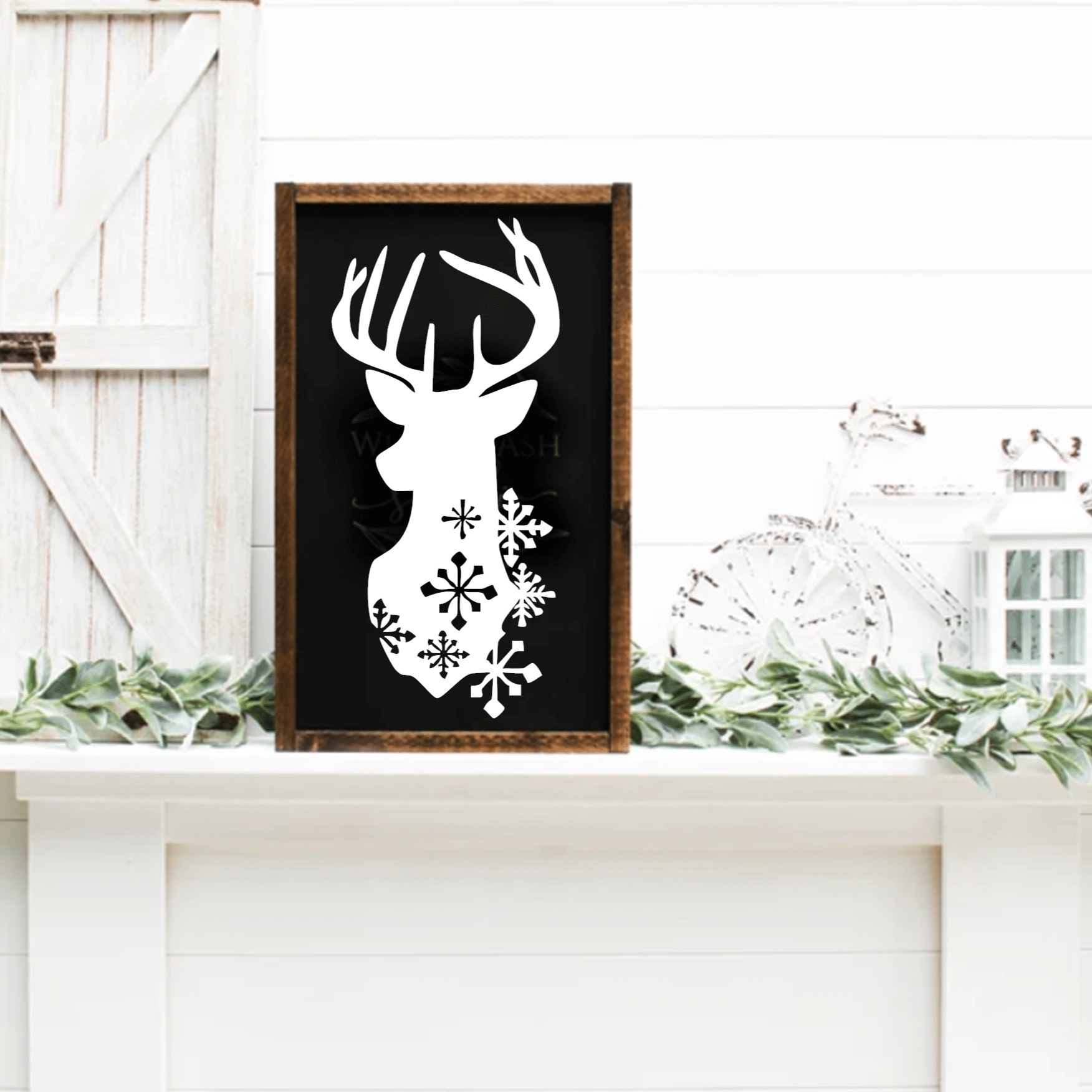 Framed Christmas deer head sign with snowflakes on black background.