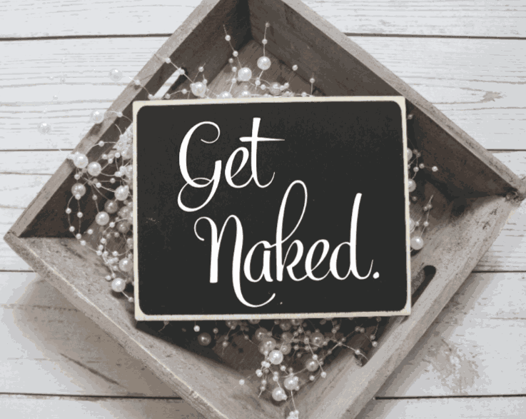 Rustic bathroom wood sign with "Get Naked" text on a black background, framed in stained pine.