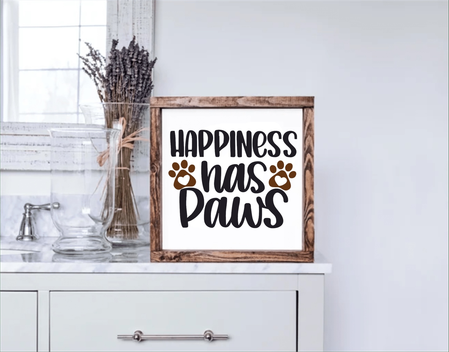 Happiness Has Paws wood sign on a shelf, framed in stained pine wood.